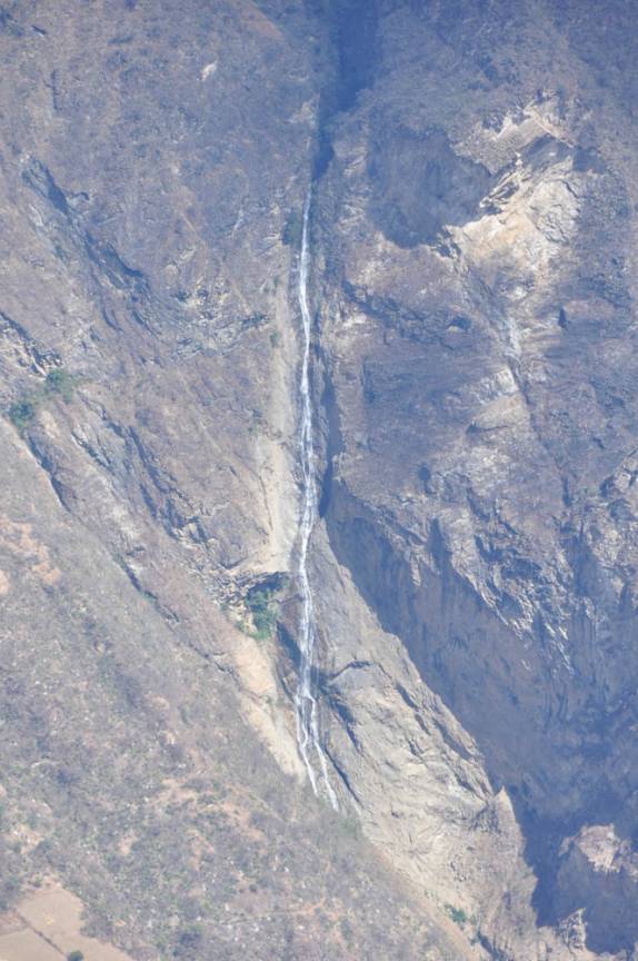 Ao longe, uma grande cachoeira embeleza a paisagem da trilha para Choquequirao, no Peru